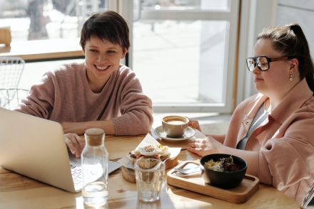 2 women meeting at a cafe looking at a laptop