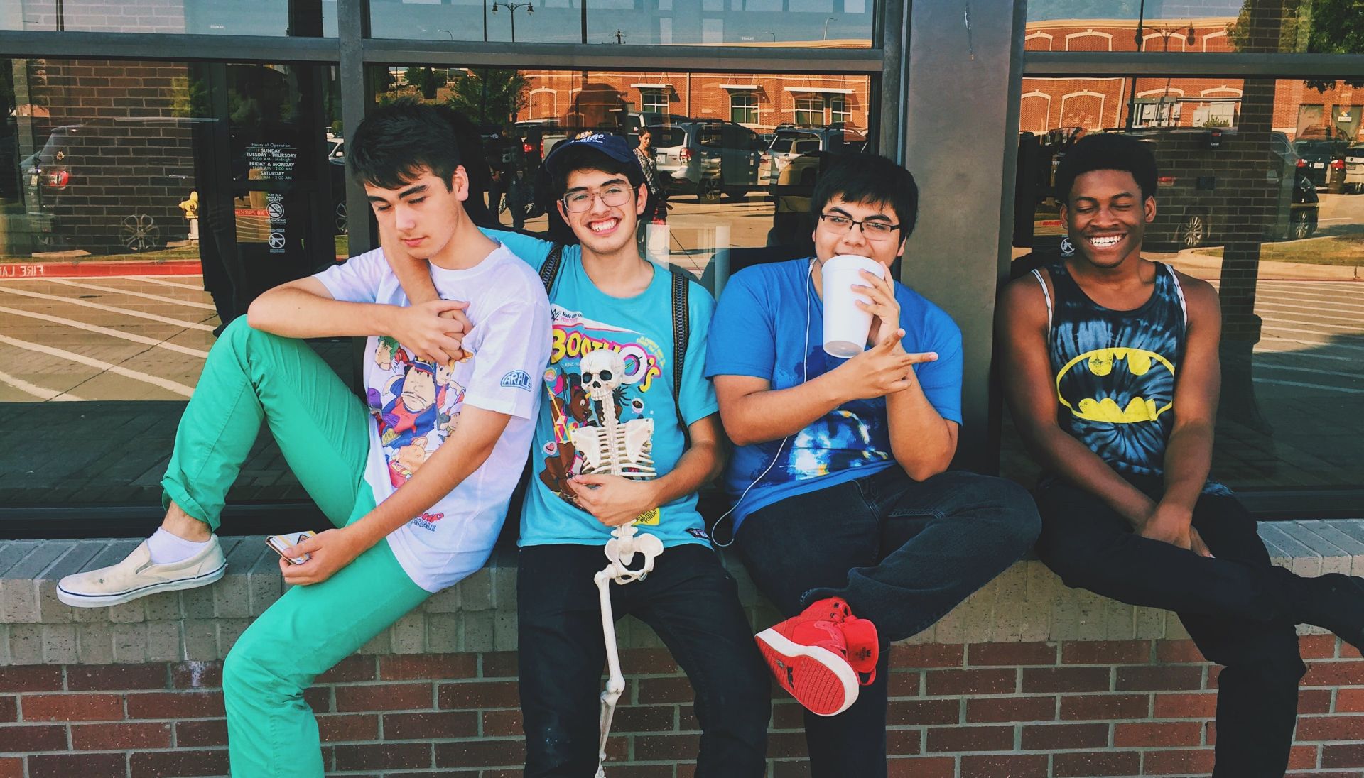 Four College Aged Young Men Sitting on Platform